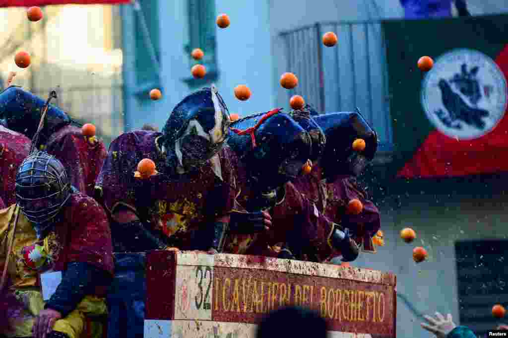 Revelers take part in a fight with oranges during an annual carnival battle in Ivrea, Italy.