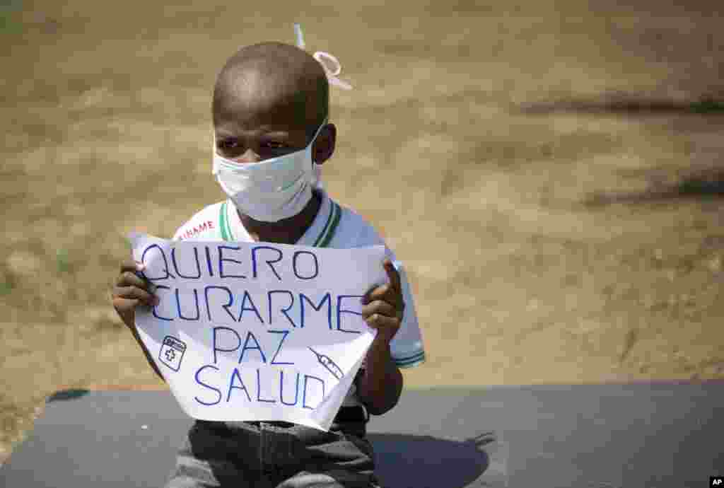 Oliver Sanchez, 8, holds a sign that reads in Spanish "I want to heal, peace, health" during a protest against the shortage of medicines and medical supplies, in Caracas, Venezuela. Oliver has Non-Hodgkin's lymphoma and his treatment was stopped a month ago because he can't find the medicine for his treatment.