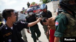 ក្រុម​ប៉ូលិស​​ចាប់​ខ្លួន​បុរស​ម្នាក់​ក្នុង​អំឡុង​ការ​ប៉ះទង្គិច​​គ្នា​ជាមួយ​ក្រុម​កម្មករ​កាត់​ដេរ​នៅ​ក្នុង​រាជធានី​ភ្នំពេញ កាល​ពី​ថ្ងៃ​ទី​១២ វិច្ឆិកា ២០១៣។