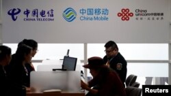 在上海舉行的中國國際進口博覽會上顯示的中國電信、中國移動和中國聯通的標識。（2018年11月5日）