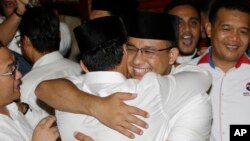 Gubernatorial candidate Anies Baswedan, center right, hugs his running mate Sandiaga Uno during a press conference in Jakarta, Indonesia, April 19, 2017. 