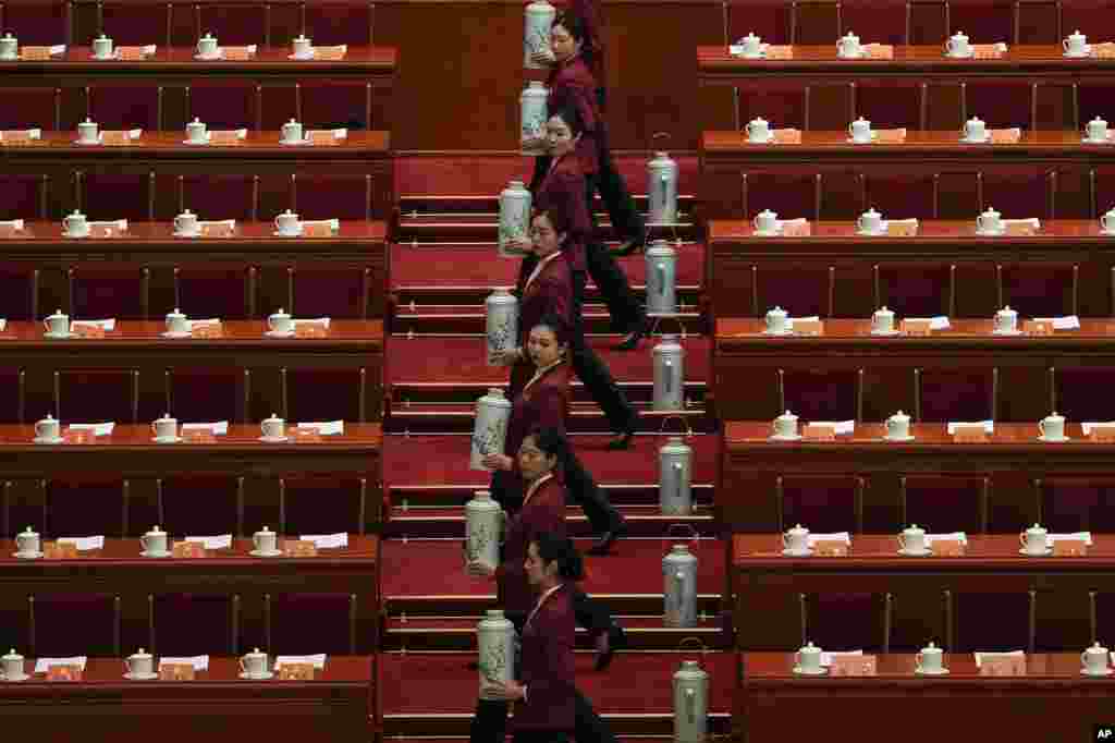 Hostesses fill up tea cups for the leaders before the opening session of the Chinese People's Political Consultative Conference at the Great Hall of the People in Beijing.
