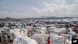 People displaced by the ongoing fighting between Congolese forces and M23 rebels gather in a camp on the outskirts of Goma, Democratic Republic of Congo, Wednesday, March 13, 2024.(AP Photo/Moses Sawasawa)