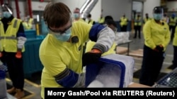 Marekani, Michigan, Portage, maboksi ya chanjo ya COVID-19 iliyotengenezwa na kampuni ya Pfizer na BioNTech yakiandaliwa kusambazwa nchini Marekani.