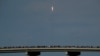 Los espectadores observan desde un puente en Titusville, Florida, mientras el SpaceX Falcon 9 despega con dos astronautas a bordo el 30 de mayo de 2020.