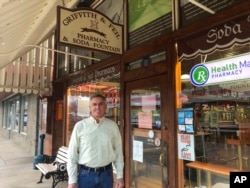 Ric Griffith appears outside of Griffith & Feil Pharmacy & Soda Fountain, a pharmacy he owns, on Jan. 15, 2021, in Kenova, W.Va. The pharmacy opened in 1892 with a soda fountain counter that was taken out in 1957 but reopened in 2004. (AP Photo/John Raby, File)