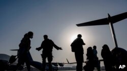 US Air Force airmen guide evacuees aboard a transport aircraft at Hamid Karzai International Airport in Kabul, Afghanistan, Aug. 24, 2021. (US Air Force photo)