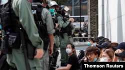 Manifestantes hongkoneses custodiados por las fuerzas del orden tras una protesta en contra de la nueva ley de seguridad, celebrada en Causeway Bay. 