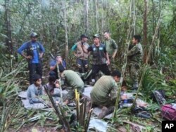 En esta foto difundida por la Oficina de Prensa de las Fuerzas Armadas de Colombia, soldados y hombres indígenas posan para la foto con los cuatro hermanos indígenas que llevaban 40 días desaparecidos, en la selva de Solano, estado de Caquetá, Colombia, el viernes 9 de junio de 2023. (Oficina de Prensa de las Fuerzas Armadas de Colombia)