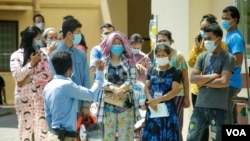 រូបឯកសារ៖ ពលរដ្ឋ​កម្ពុជា​មួយចំនួន​ឈរ​មើល​លោក​នាយក​រដ្ឋមន្ត្រី​ ហ៊ុន សែន​ មក​ទទួល​​ការ​ចាក់​​វ៉ាក់សាំង​បង្ការ​ជំងឺ​កូវីដ១៩​​ របស់​ក្រុមហ៊ុន​ AstraZeneca​ នៅ​មន្ទីរពេទ្យ​កាល់ម៉ែត​​ ភ្នំពេញ​ ថ្ងៃទី៤​ ខែមីនា​ ឆ្នាំ២០២១។​ (ហ៊ាន សុជាតា/​វីអូអេ​)