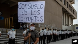 Miles de guatemaltecos protestaron la semana pasada en todo el país para exigir la renuncia de la fiscal general Consuelo Porras y del presidente Alejandro Giammattei, un manifestante porta en una protesta un cartel alegórico al momento. (Foto archivo)