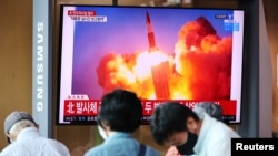 People watch a TV broadcasting file footage of a news report on North Korea firing what appeared to be a pair of ballistic missiles off its east coast, in Seoul, South Korea, September 15, 2021.
