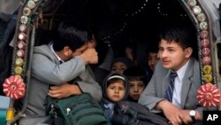 Pakistani students go to their school near Army Public School targeted by Taliban militants, in Peshawar, Pakistan, Monday, Jan. 12, 2015.