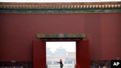 អ្នក​ទេសចរ​ម្នាក់​ដែល​ពាក់​ម៉ាស់​ការពារ​មេរោគ​កូរ៉ូណា​ដើរ​កាត់​វិមាន Forbidden City ក្នុង​ក្រុង​ប៉េកាំង កាលពី​ថ្ងៃទី១ ខែឧសភា ឆ្នាំ២០២០។