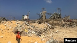 A man walks near rubble at the site of Tuesday's blast, at Beirut's port area, Lebanon, Aug. 7, 2020. 