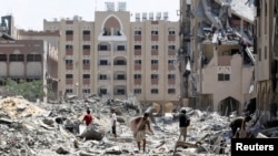 Жители сектора Газа осматривают ущерб, нанесенный финансируемому Катаром городу Хамад Сити, в окрестностях Хан-Юниса, 24 августа 2024 года. (фото REUTERS/Хатем Халед).