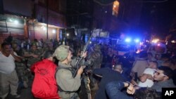 A Lebanese soldier opens fire into the air to disperse people who gathered around a man (on the ground) whom they claimed was a suspected attacker in Burj al-Barajneh, southern Beirut, Lebanon, Thursday, Nov. 12, 2015.