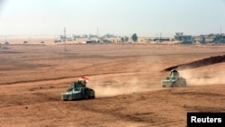 هێزەکانی پێشمەرگە لە کاتی شەڕ لە گەڵ داعش لە هێڵی پێشەوە لە گوندی تۆپز ئاوای نزیک باشیکا، ٢٤ی ئوکتۆبری٢٠١٦