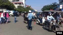 ប៉ូលិស​មួយ​រូប​កំពុង​ត្រួត​ពិនិត្យ​ចរាចរណ៍។