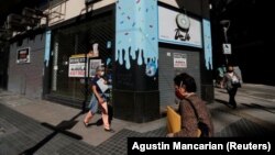Pedestrians walk past out-of-business stores which display "For rent" signs, near the Buenos Aires' Obelisk, Argentina April 6, 2021. (REUTERS/Agustin Marcarian)