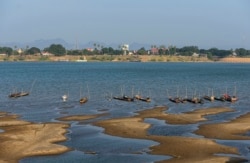 FILE - Fishing boats are moored in Mekong River, which has turned blue instead of its usual muddy color, in Nakhon Phanom province, northeastern Thailand, Dec. 4, 2019.
