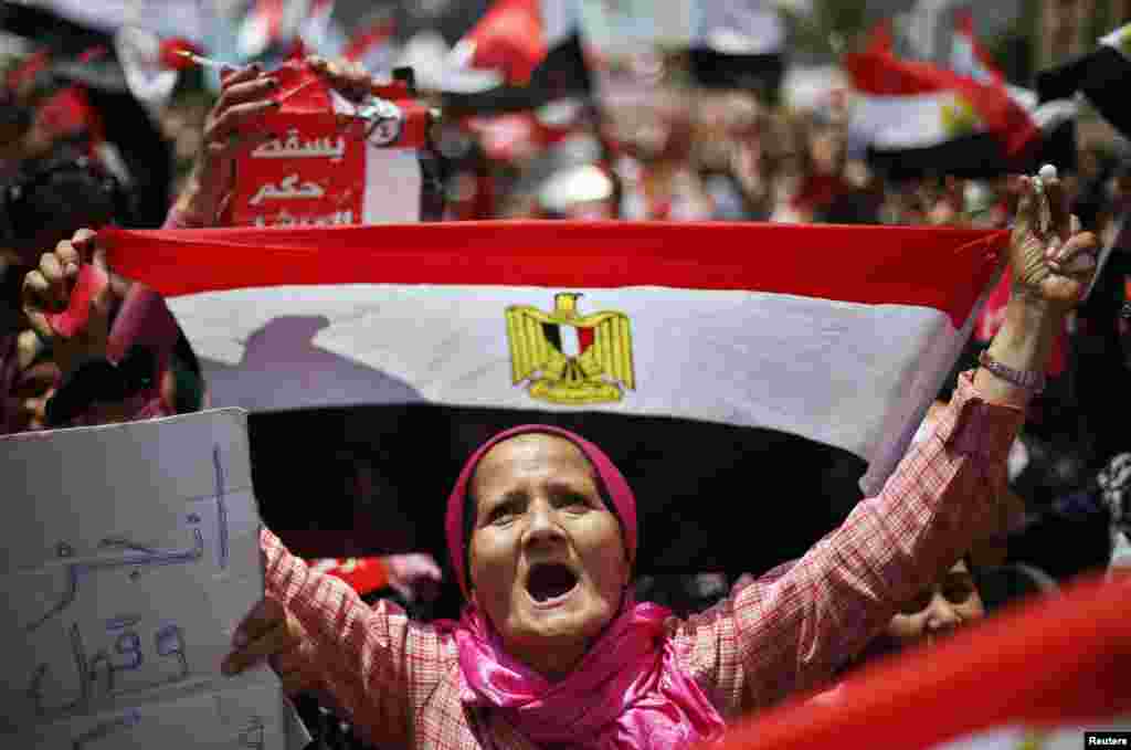 A protester, opposing Egyptian President Mohamed Morsi, holds up Egypt's flag during a protest demanding that Morsi resign at Tahrir Square in Cairo, July 2, 2013. 