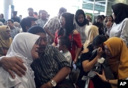 Relatives of passengers comfort each other as they wait for news on a Lion Air plane that crashed off Java Island at Depati Amir Airport in Pangkal Pinang, Indonesia Monday, Oct. 29, 2018.
