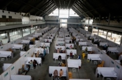Senior citizens receive the Sinopharm coronavirus vaccine from health workers at a vaccination site in Lahore, Pakistan, March 18, 2021.