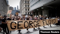 Protestantes marchan por la muerte en Minneapolis de George Floyd, mientras estaba bajo custodia policial.