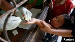 FILE - Children living in the Thai-Myanmar border come to a malaria clinic to get tested in Sai Yoke district, Kanchanaburi province, Thailand, Oct. 26, 2012.