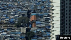 A high-rise residential building is seen next to a slum in Mumbai, India, Dec. 20, 2017.