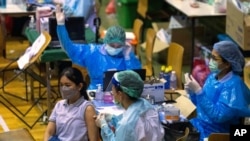 A health worker administers a dose of the Sinovac COVID-19 vaccine to a woman at Thai-Japan Bangkok Youth Center in Bangkok, Thailand, Monday, June 14, 2021. (AP Photo/Sakchai Lalit)