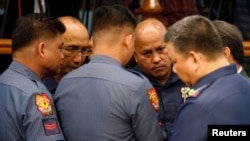 Philippine National Police chief Director-General Ronald dela Rosa (2nd-R) talks to fellow police officers during a Senate hearing regarding people killed during a crackdown on illegal drugs in Pasay, Metro Manila, Philippines, Aug. 23, 2016.