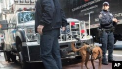 Emergency service personnel with a bomb sniffing dog work outside the building that houses New York Governor Andrew Cuomo's office after a report of a suspicious package, Oct. 24, 2018, in New York.
