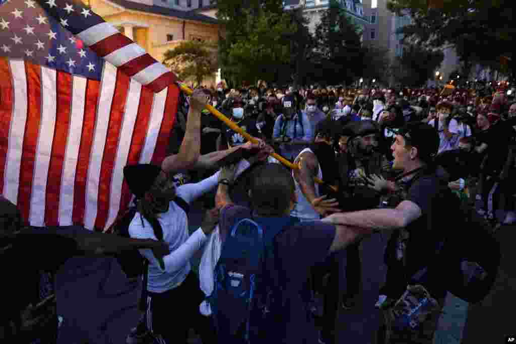 ក្រុមបាតុករ បាន​ប៉ះទង្គិចគ្នា​នៅ​ពេល​ដែល​មនុស្ស​ប្រមូលផ្តុំគ្នា​ដើម្បី​តវ៉ា​អំពី​ការស្លាប់​របស់​លោក George Floyd នៅ​ថ្ងៃសៅរ៍​ទី ៣០ ខែឧសភា ឆ្នាំ ២០២០ ក្បែរ​សេតវិមាន​ក្នុង​រដ្ឋធានី​វ៉ាស៊ីនតោន។ លោក Floyd បាន​ស្លាប់ បន្ទាប់ពី​ត្រូវបាន​ឃាត់ខ្លួន​ដោយ​ប៉ូលិស​នៅ​ទីក្រុង Minneapolis រដ្ឋមីនីសូតា សហរដ្ឋ​អាមេរិក កាលពី​ថ្ងៃចន្ទ ទី ២៥ ខែឧសភា ឆ្នាំ២០២០។ (AP) 