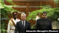 Los presidentes de Cuba, Miguel Díaz-Canel (izq), y Venezuela, Nicolás Maduro, pasan revista a la guardia de honor durante una ceremonia en el Palacio de la Revolución en La Habana. 21 abril 2018. 