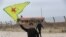 FILE - A Syrian Kurd waves the flag of YPG (People's Protection Units) near Qamishli's airport in northeastern Syria on December 8, 2024, following the fall of the capital Damascus to anti-government fighters.