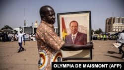 Un partisan du CDP tient un portrait de l'ancien président du Burkina Faso, Blaise Compaoré, lors d'un rassemblement de campagne le 19 novembre 2020.