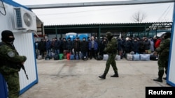 Ukrainian citizens are guarded by Russia-backed separatist fighters during a prisoner swap near Mayorsk, Donetsk region, Ukraine, Dec. 29, 2019. 