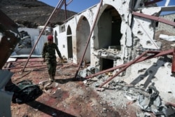 FILE - A soldier walks at the site of a Houthi missile attack on a military camp’s mosque in Marib, Yemen, Jan. 20, 2020.