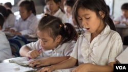 FILE - Primary students are reading during a classroom session at Kesararam primary school, in Siem Reap province, on Friday, March 20, 2015. (Nov Povleakhena/VOA Khmer)