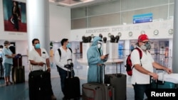 Un grupo de viajeros aguarda turno en el aeropuerto internacional de Sandio, en Managua, entre estrictas medidas de prevención.