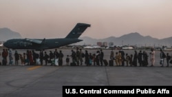 Evacuees wait to board a Boeing C-17 Globemaster III during an evacuation at Hamid Karzai International Airport, Kabul, Afghanistan, Aug. 23. (US Marine Corps photo)