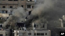 FILE - Houses are engulfed in fire as the Israeli army raided the northern West Bank town of Qabatiya, Sept. 19, 2024. 