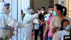 资料照片：中国福建省莆田仙游县的居民排队接受新冠核酸检测。（2021年9月13日）