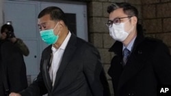 香港壹傳媒創辦人黎智英（左）獲得保釋離開香港高等法院。（2020年12月23日）