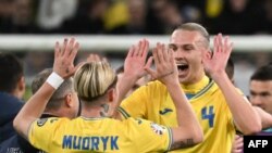 Ukraine's midfielder #10 Mykhaylo Mudryk and Ukraine's defender #04 Maksym Talovierov celebrate after the UEFA's EURO 2024 qualification final play off football match between Ukraine and Iceland, in Wroclaw, Poland, on March 26, 2024.