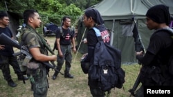 Members of special police force chat after returning to a police camp near Wang Kelian in northern Malaysia, close to the border with Thailand May 25, 2015. Malaysian authorities have found 139 graves, and signs of torture, in more than two dozen squalid