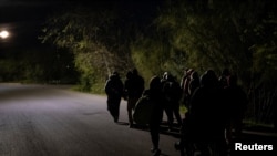 Migrantes caminan por una carretera en la mañana de Navidad para cruzar el río Grande hacia Eagle Pass, Texas, desde Piedras Negras, Coahuila, México, el 25 de diciembre de 2023.