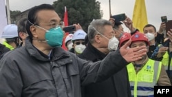 El primer ministro chino, Li Keqiang (izquierda) habla durante su visita a un hospital que está siendo construido para tratar pacientes del mortal brote del coronavirus en Wuhan, China, el lunes, 27 de enero de 2020.